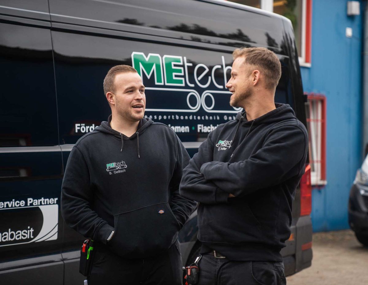 Zwei MEtech-Monteure vor dem Servicefahrzeug